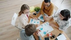 A team discussing data at a table — illustration for an article about the My team section