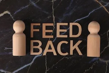 Деревянные фигурки и надпись FEEDBACK — иллюстрация к статье про оценку 360 градусов